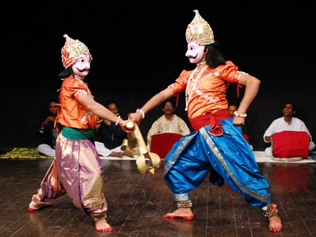 children dressed like men, play fighting on stage at a dawali celebration
